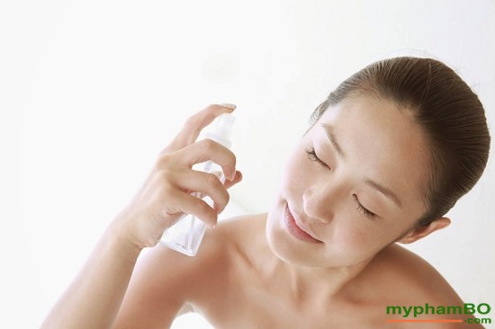 young woman spraying on face for skin care